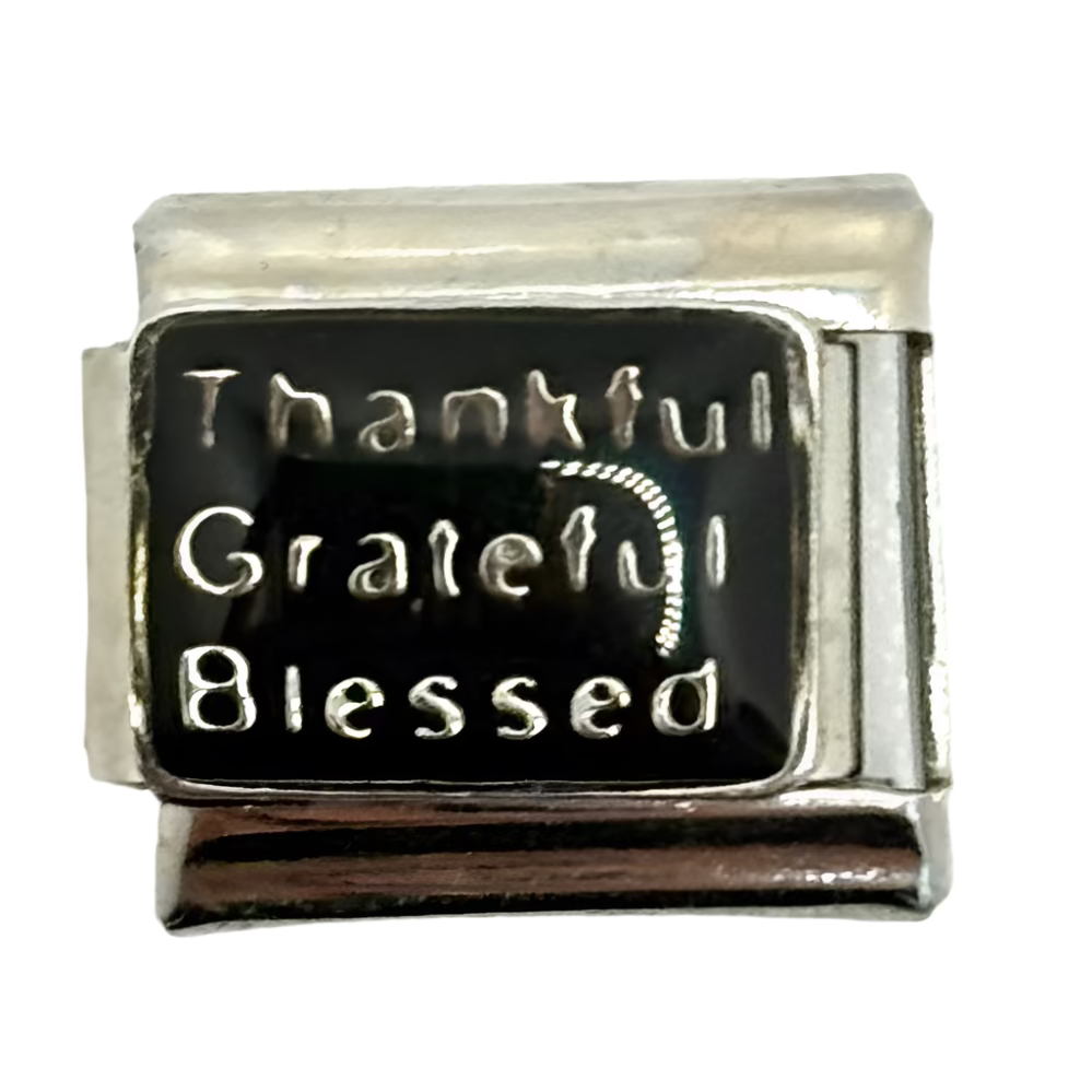 Silver charm with 'Thankful Grateful Blessed' text on a white background