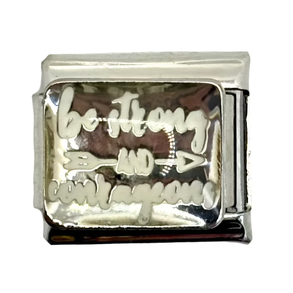 Silver charm with engraved text and design on a white background