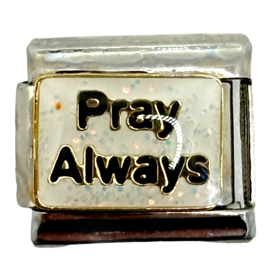 Small metallic charm with 'Pray Always' text on a white background